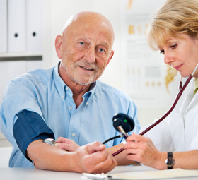 Female doctor measuring blood pressure of senior  man