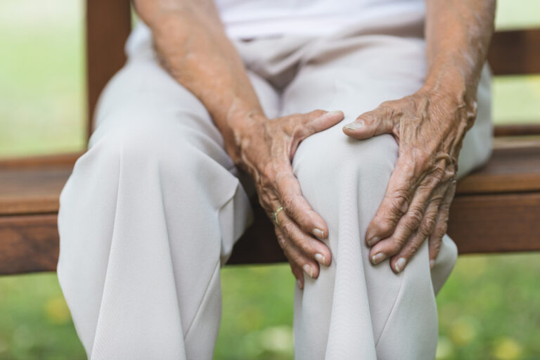 Senior woman holding her painful knee