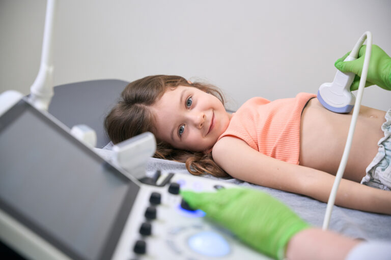Doctor reviewing ultrasound results with child lying on the table