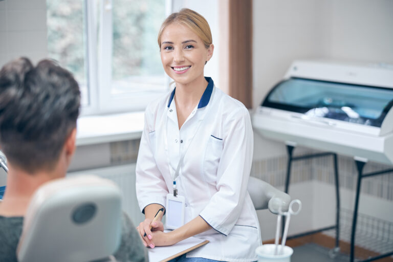 Happy female dentist during male visit to clinic