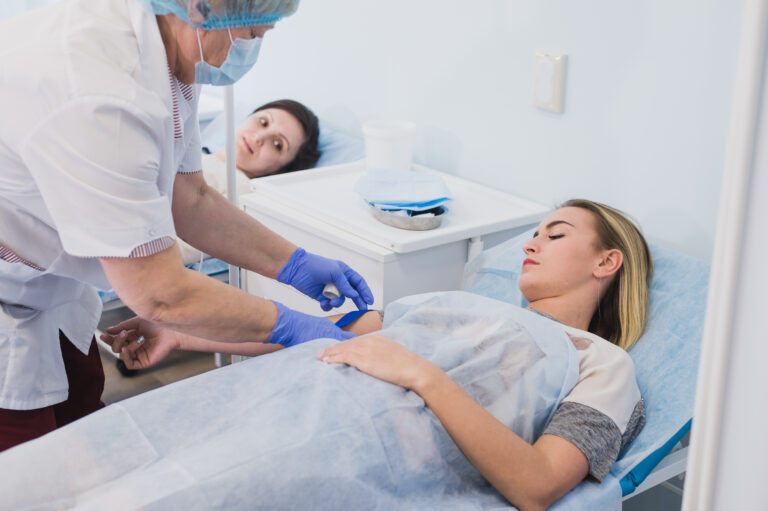 Nurse connecting an intravenous drip in hospital room