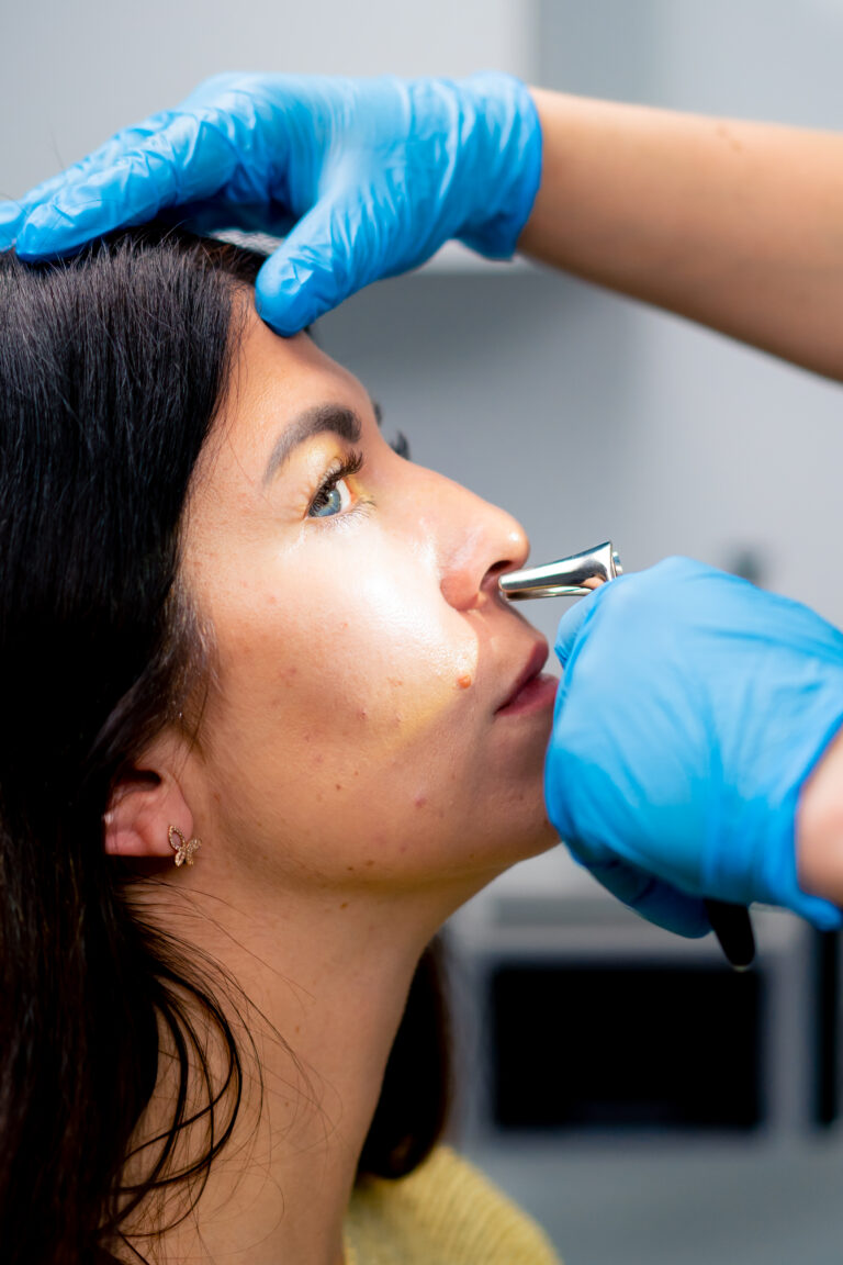 close-up ENT doctor examines the nasal cavity of the patient in the office of clinic with professional tools