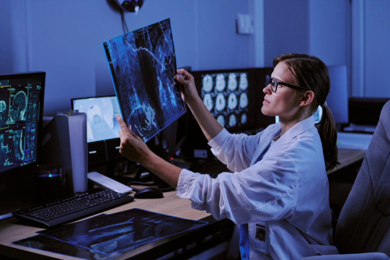 Caucasian Young Adult Woman Radiologist Examining X Ray Scan in Hospital Office